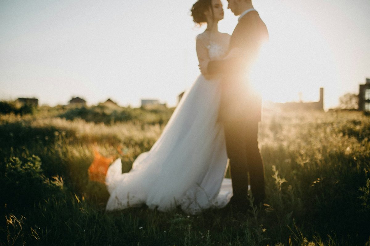 Couple face to face in backlit grass